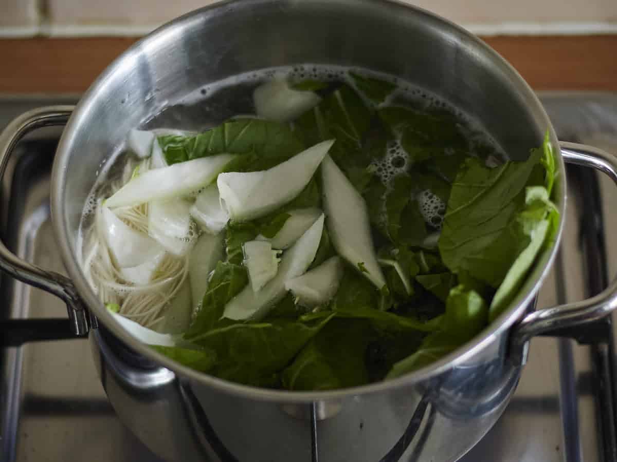Noedels en paksoi koken voor Dan Dan Noedels